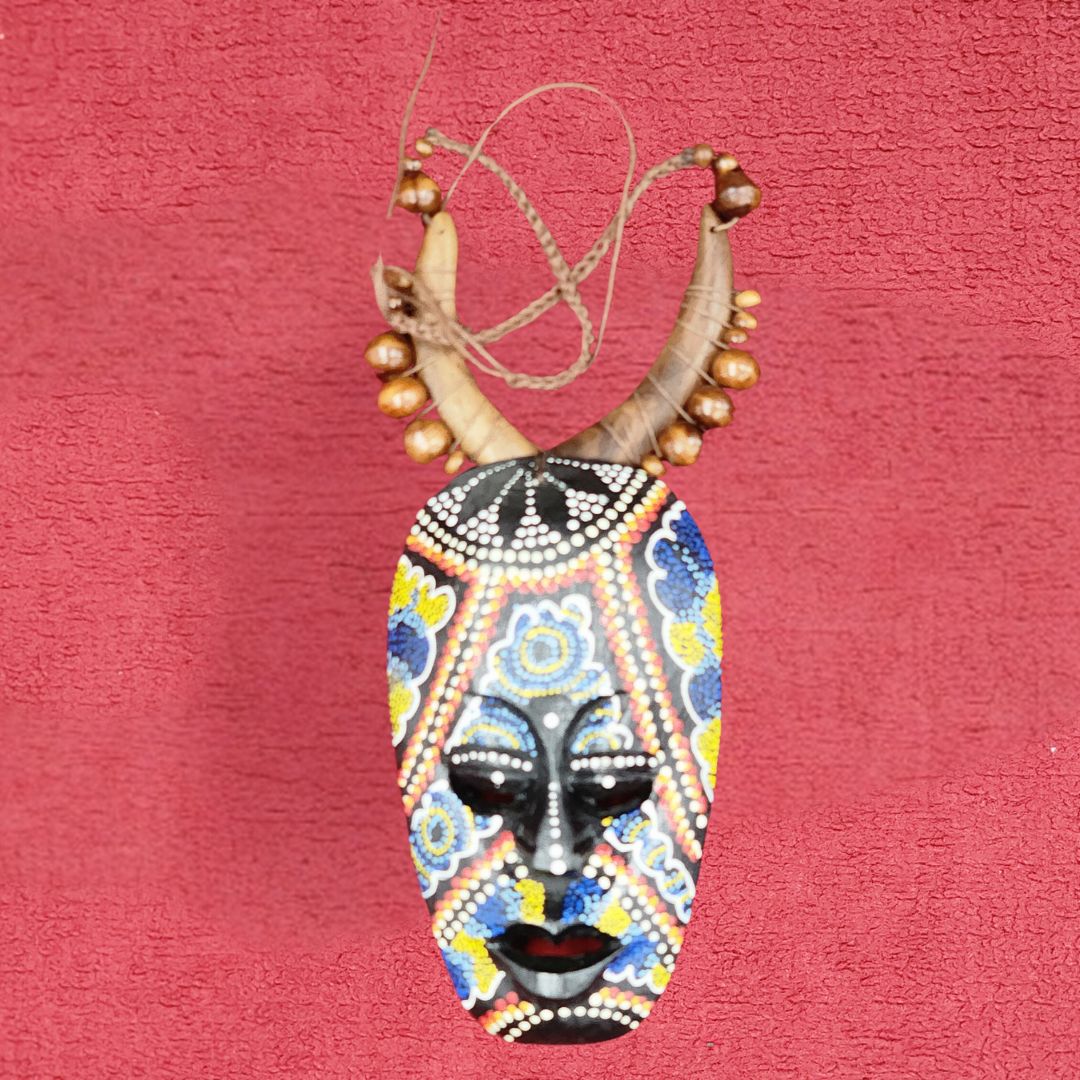 Ancestral Echoes Mask Necklace featuring a handcrafted wooden pendant with intricate African-inspired beadwork and horn accents. A unique tribal jewelry piece.