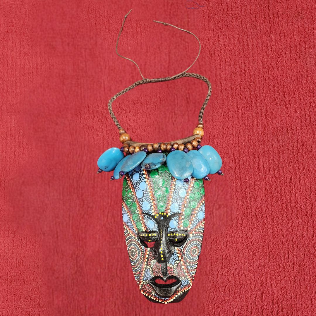 Azure Serenity Mask Pendant featuring intricate beadwork and wooden accents on a braided cord. A unique African-inspired handmade necklace.