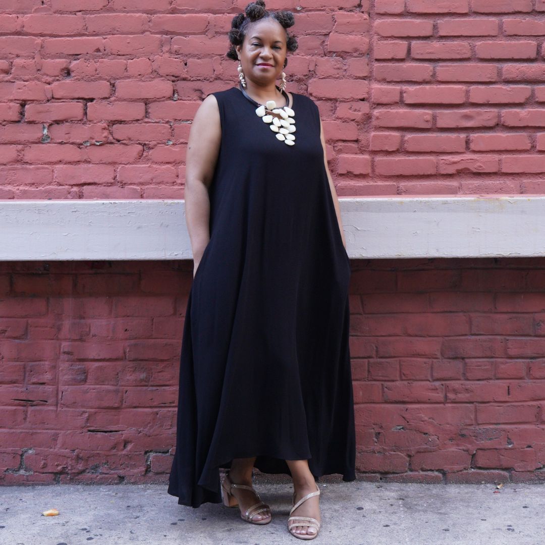 Classic black maxi dress with pockets, styled with a statement necklace. A comfortable and versatile outfit for any occasion.