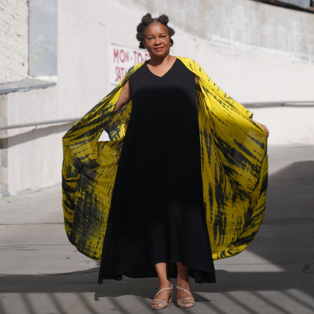 Black maxi dress with a striking yellow tie-dye cape, creating a dramatic and stylish ensemble. Ideal for making a bold fashion statement.