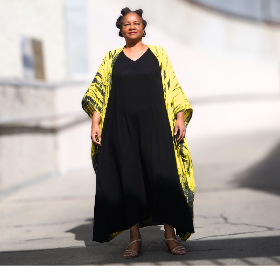 Comfortable black maxi dress with pockets, paired with a vibrant yellow tie-dye cape. A stylish and effortless outfit for any season.