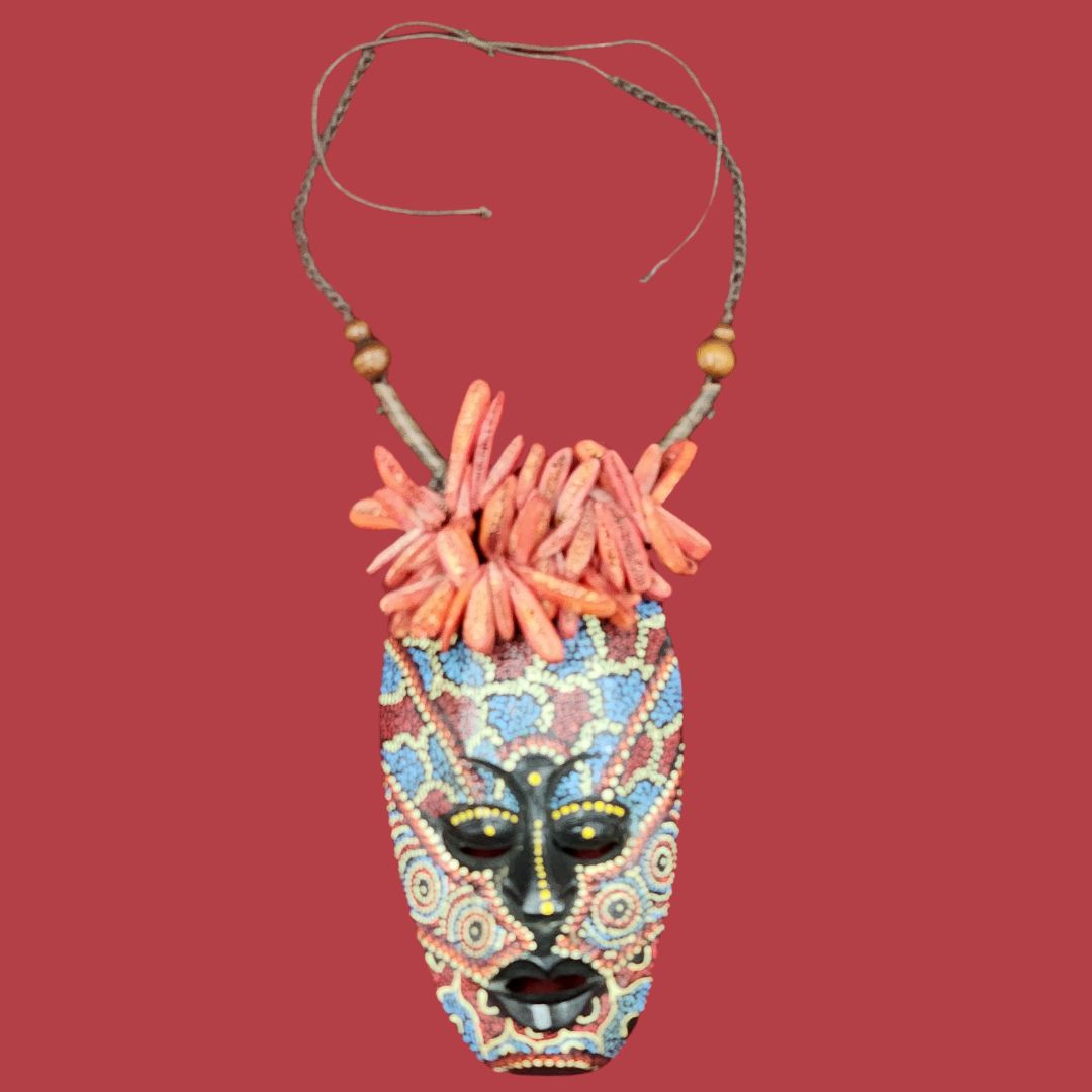 Handmade Coral Reef Mask Necklace featuring a beaded African mask pendant with wooden beads and coral accents. Unique tribal-inspired jewelry piece.