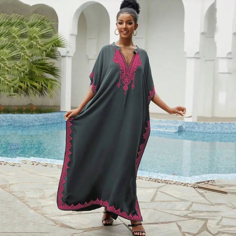 Dark green embroidered kaftan with pink detailing, featuring a flowing silhouette and V-neck, ideal for casual or ceremonial occasions.