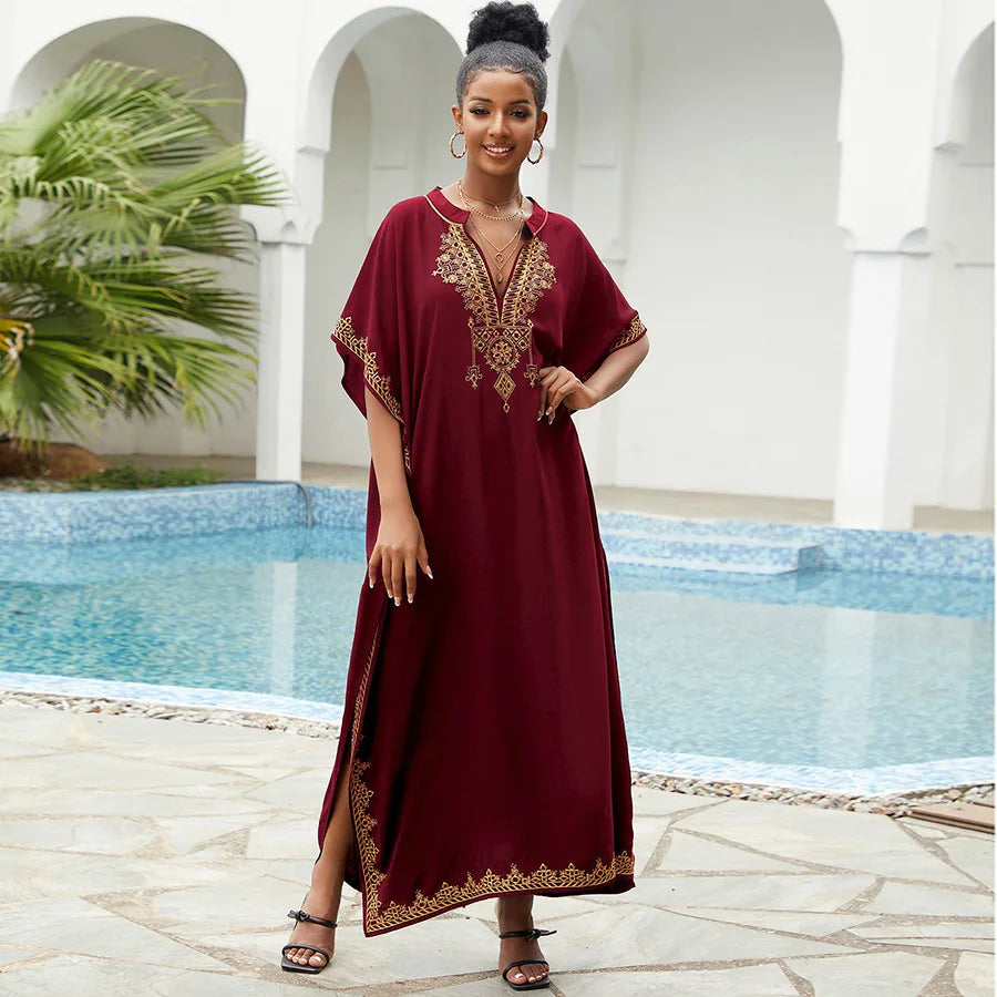 Elegant embroidered kaftan in deep burgundy with gold detailing, featuring a V-neck and flowing silhouette, perfect for traditional or beachwear.