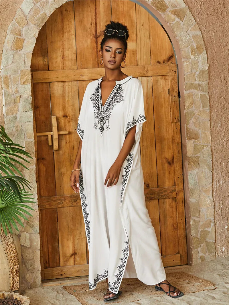 Graceful white kaftan with black embroidery, featuring a V-neck and flowing design, perfect for traditional or casual wear.