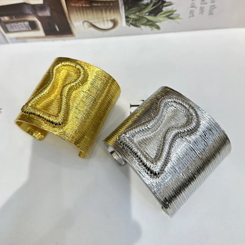 Exaggerated keyhole hair cuff shown in both gold and silver colors side by side.