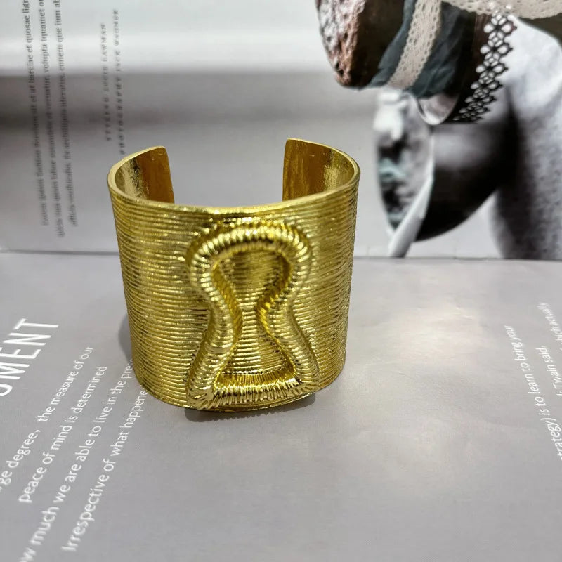 Gold exaggerated keyhole hair cuff displayed upright with detailed texture.