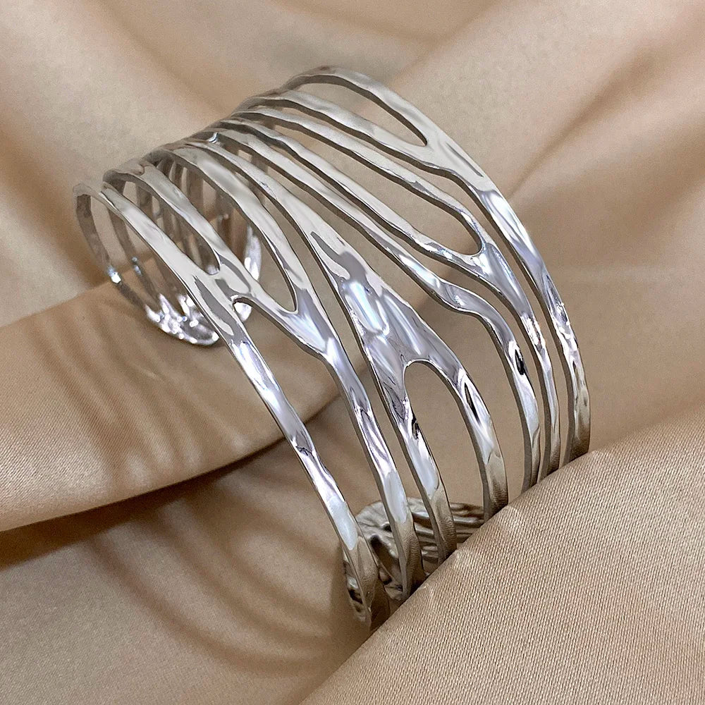 Gold Irregular Hollow Hair Cuff with wide geometric openwork design, displayed on satin fabric