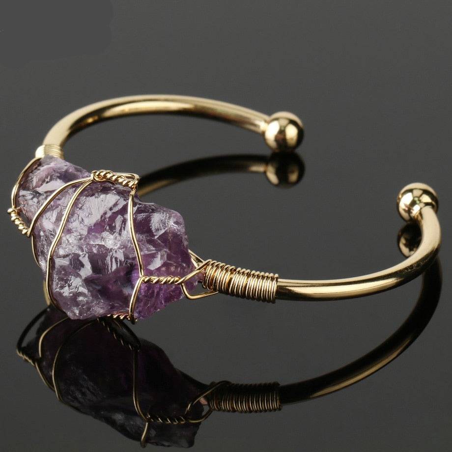Gold-tone copper bracelet with a wire-wrapped irregular amethyst crystal quartz centerpiece.