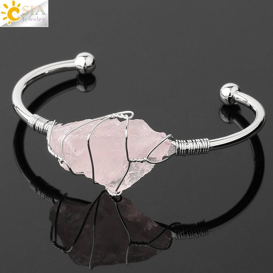 Silver-tone copper bracelet with a wire-wrapped irregular rose quartz crystal centerpiece.