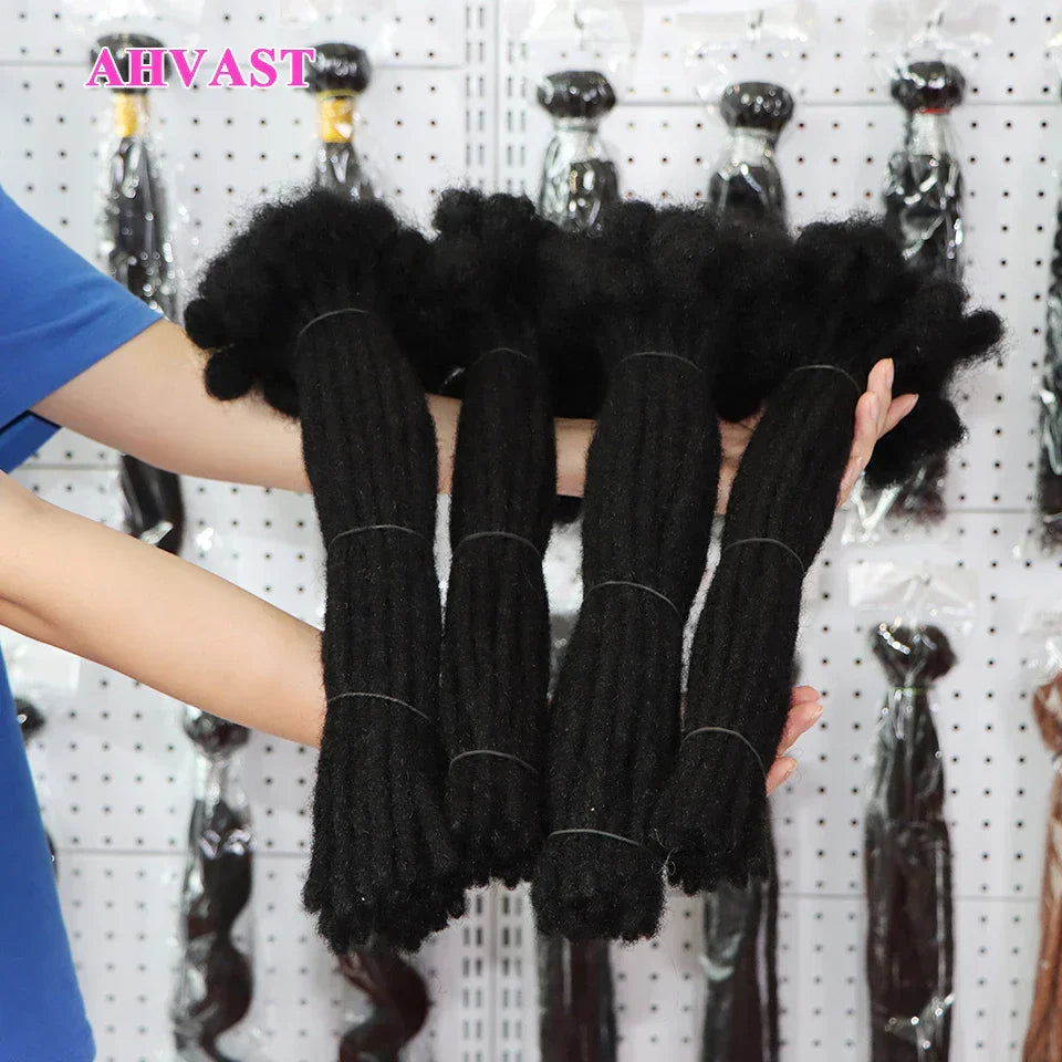 Close-up of hands holding thick black human hair loc extensions. The 0.6 cm thick locs offer a dense and natural appearance.