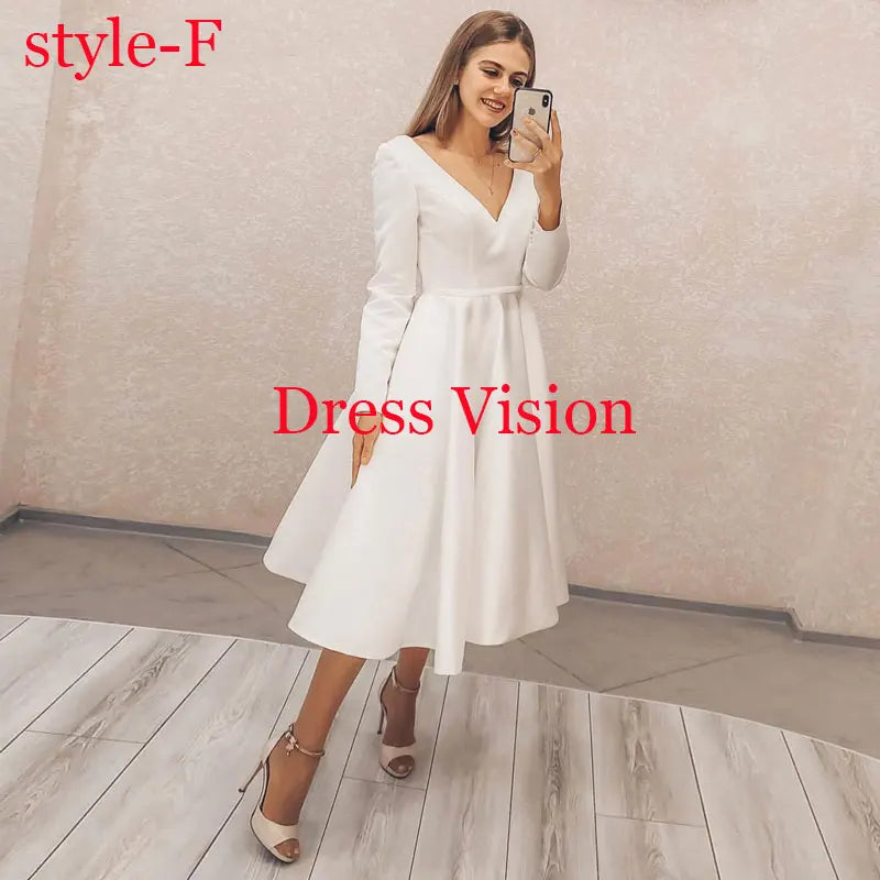 White midi dress with a deep V-neckline and long sleeves, styled with nude heels. A classic and sophisticated bridal look.