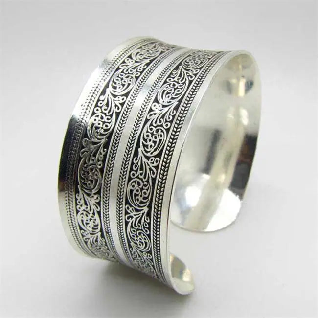 Vintage elegance cuff bracelet for women featuring intricate filigree patterns on a wide silver-tone band. A stylish accessory for any outfit.