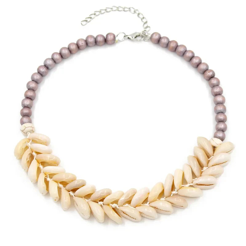 Handmade Cowrie Shell Necklace featuring purple beads and an adjustable clasp. A perfect boho accessory for summer and beach outfits.