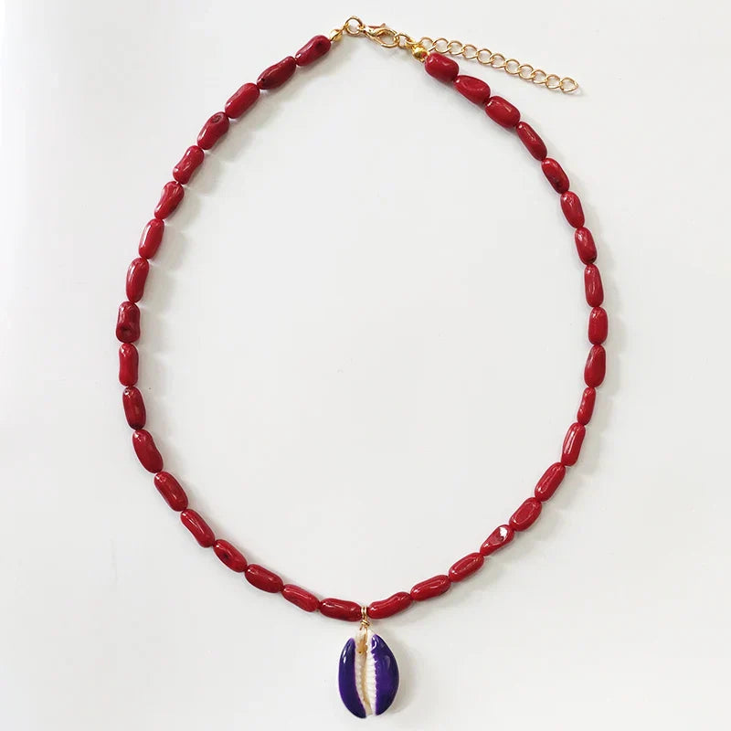 Red Beaded Handmade Cowrie Shell Necklace with a purple shell pendant, a bold and stylish statement piece.