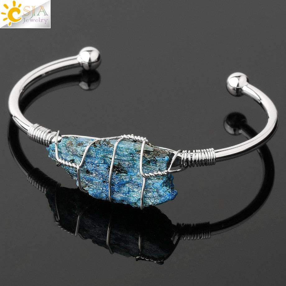 Silver-tone copper bracelet with a wire-wrapped irregular blue crystal quartz centerpiece.