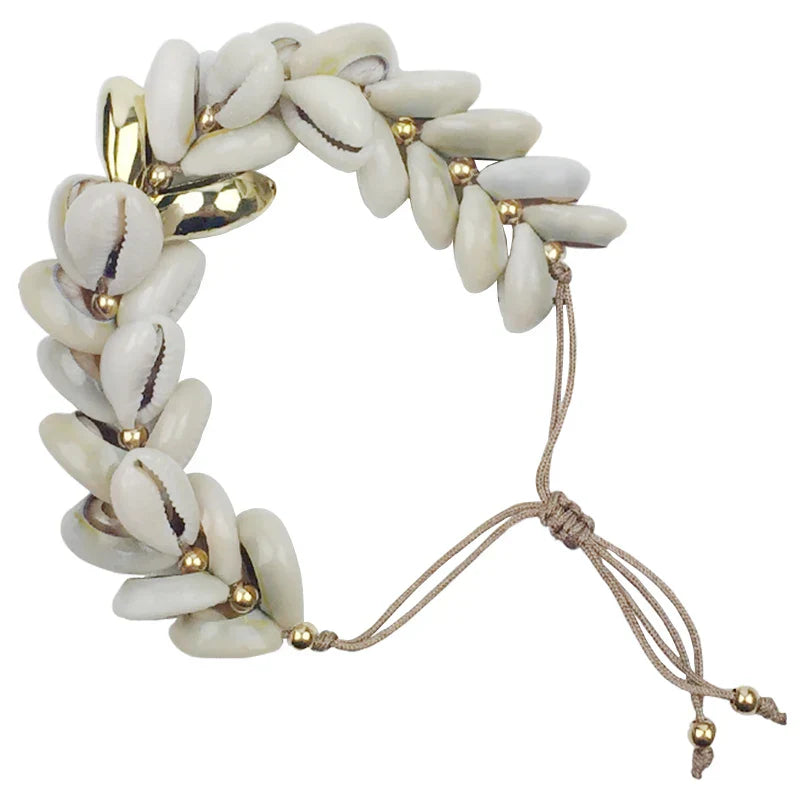 Adjustable Handmade Cowrie Shell Bracelet with gold accents, perfect for adding a touch of elegance to any outfit.
