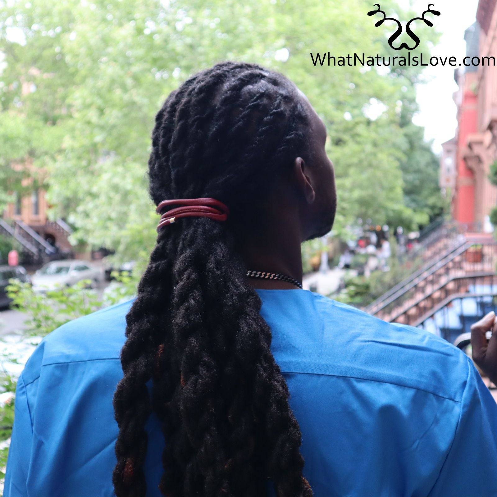 Close-up of a man’s dreadlocks tied with a red ponytail holder. A non-damaging hair tie designed for locs, braids, and sisterlocks.