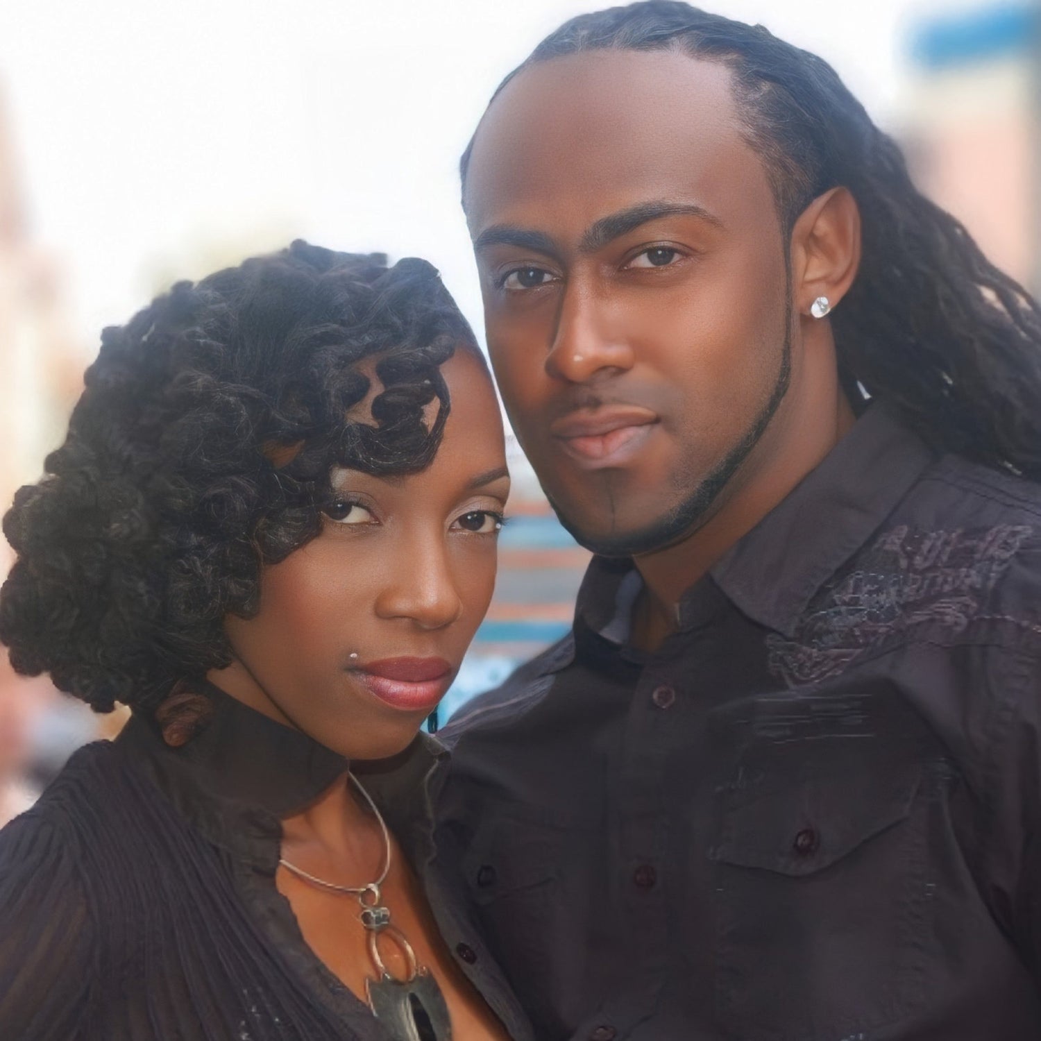 Locs styled a couple. Woman with curled styled Dreadlocks and a Man with long locs crinkled.
