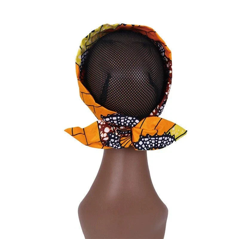 Back view of an African hair bow band headdress in orange and brown, tied elegantly on a mannequin. A traditional and modern head accessory.