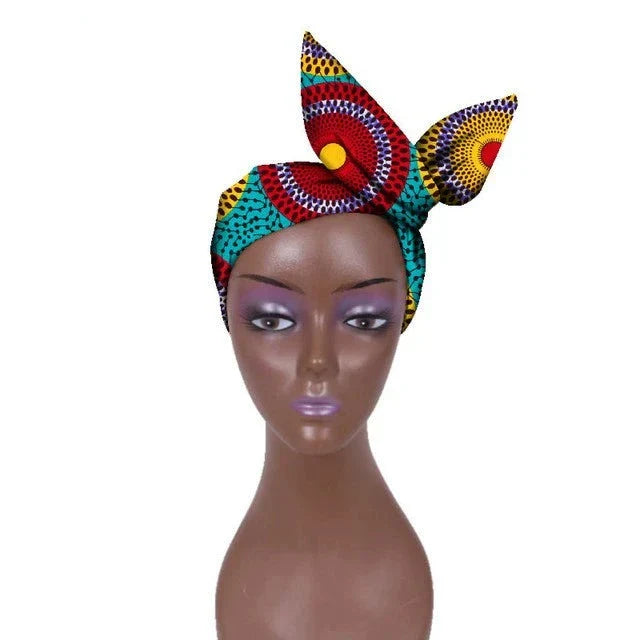 Multicolored African hair bow band headdress with circular patterns, displayed on a mannequin. A vibrant and cultural fashion piece.