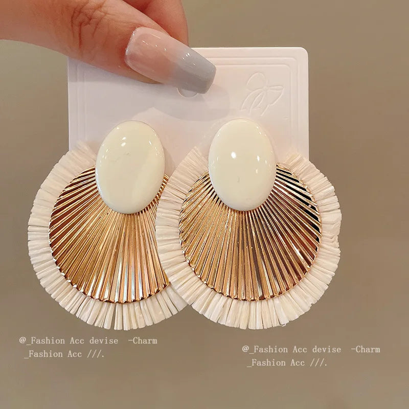 Ivory and gold fan tassel earrings with bold design, featuring a lightweight structure and elegant tassels. Perfect for casual or formal wear.
