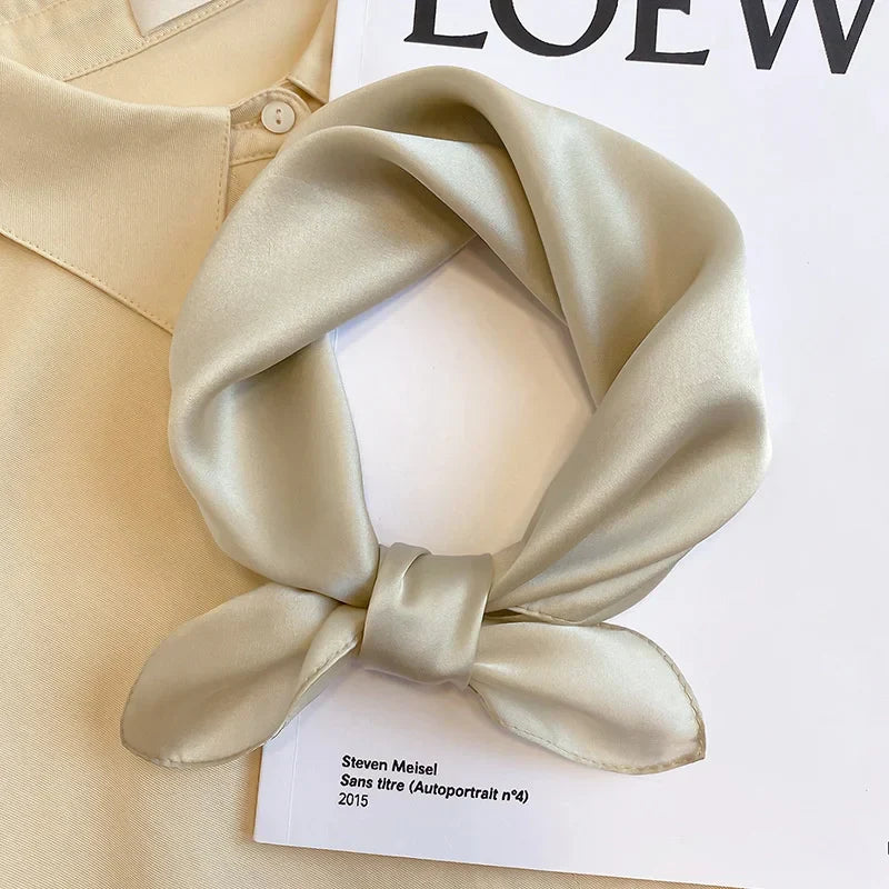 Silk Bandana Scarf - Ivory Elegant displayed on a beige shirt and LOEWE magazine, showcasing its smooth 100% silk texture and timeless hue.