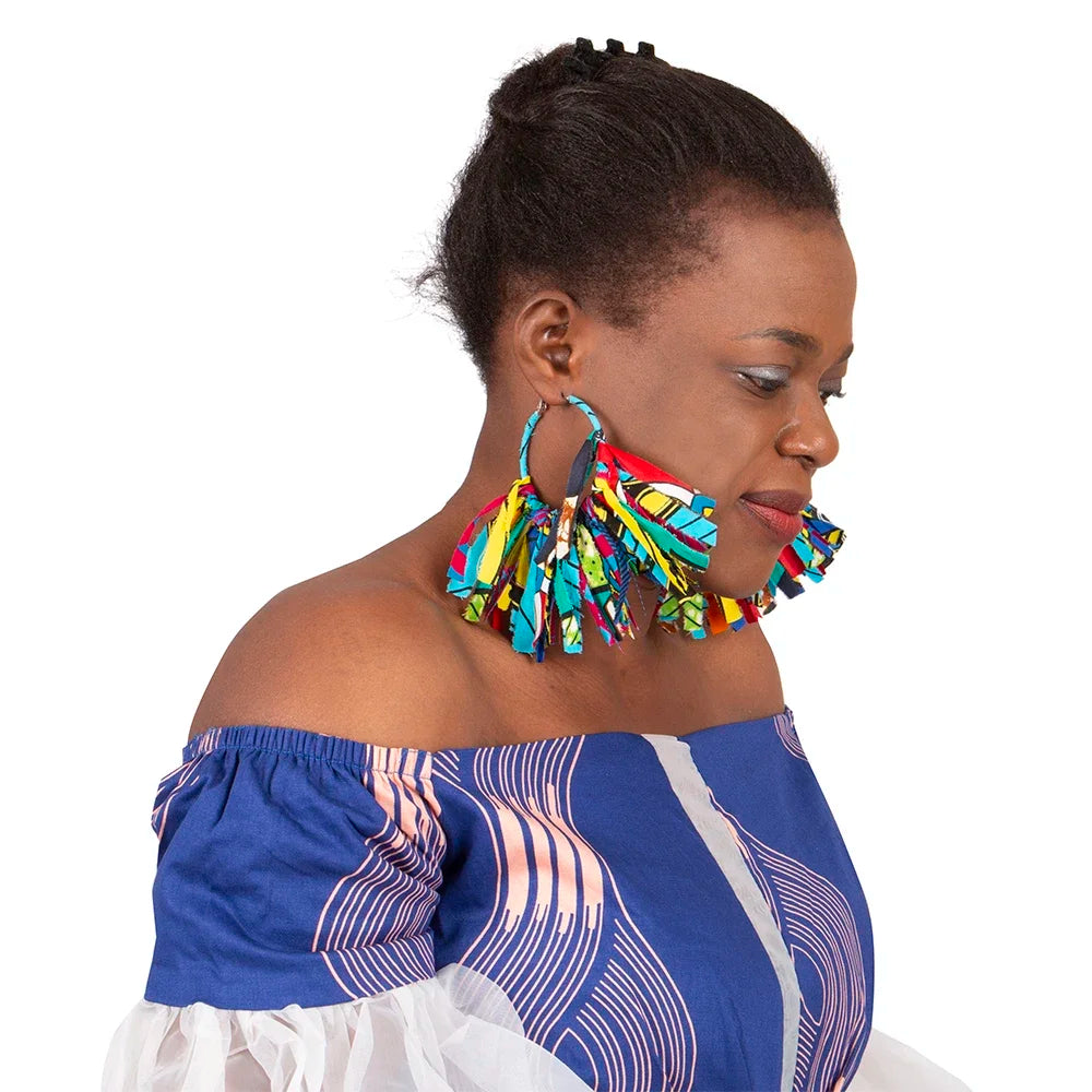 Close-up of handmade African fabric earrings with tassels. Features a secure clasp and fabric-wrapped hoop for a unique look.