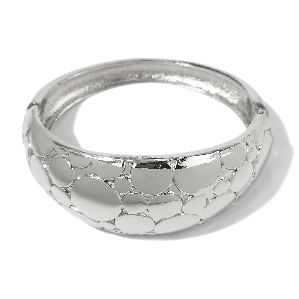 Silver-toned textured cuff bracelet with a unique bubble design. A stylish and elegant accessory for special occasions.
