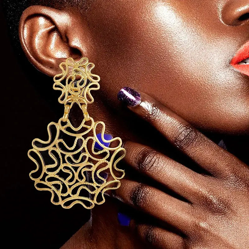 Statement two-tone 18k gold plated starry earrings worn by a model, featuring an intricate gold and silver filigree pattern for a bold look.
