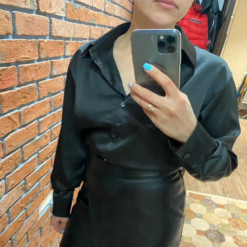 Deep navy satin blouse with a loose fit and button-down front. A timeless and elegant piece for any wardrobe.