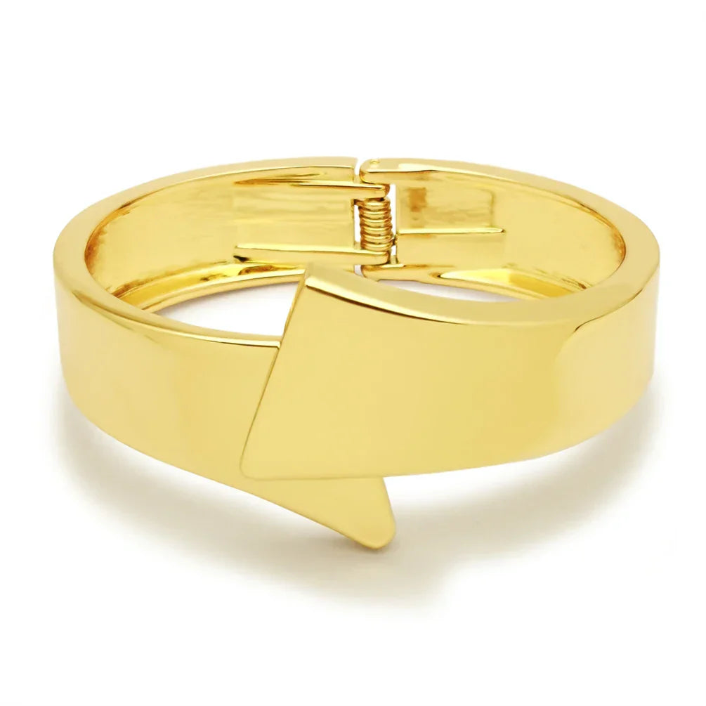 Gold-toned cuff bracelet with a geometric arrow design. A stylish and elegant accessory for special occasions.
