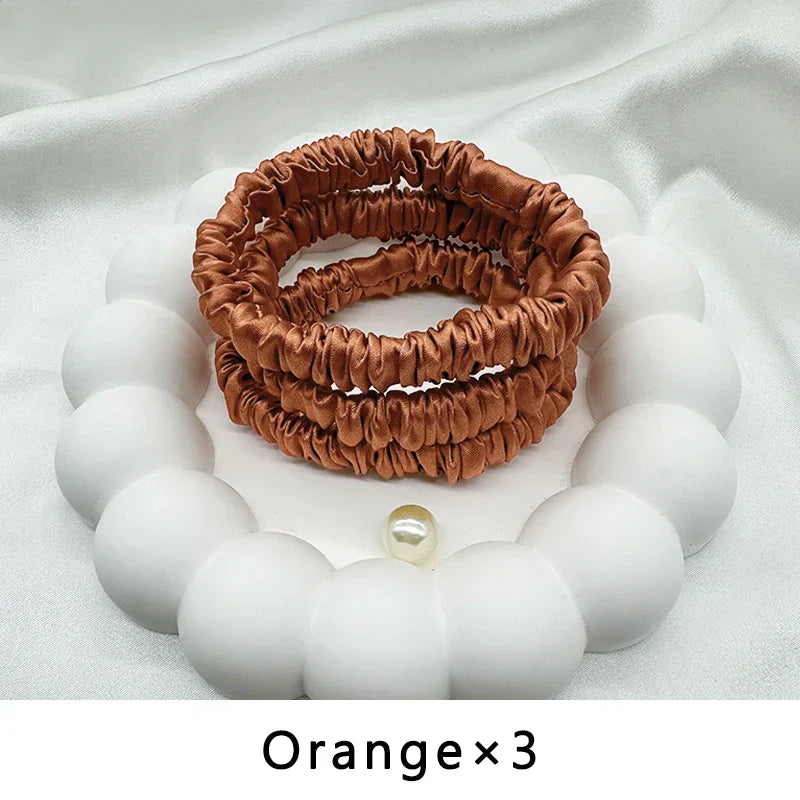 Set of three orange mulberry silk elastic hair bands. Gentle, frizz-free hold for curly and textured hair.