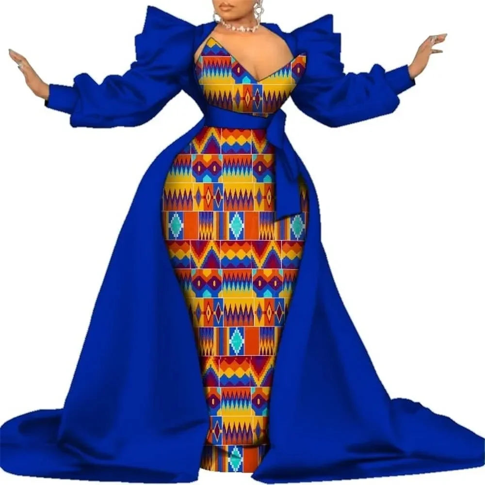 Royal blue satin overlay gown with a colorful geometric kente-style print panel, puff sleeves and a long train, on a white background.