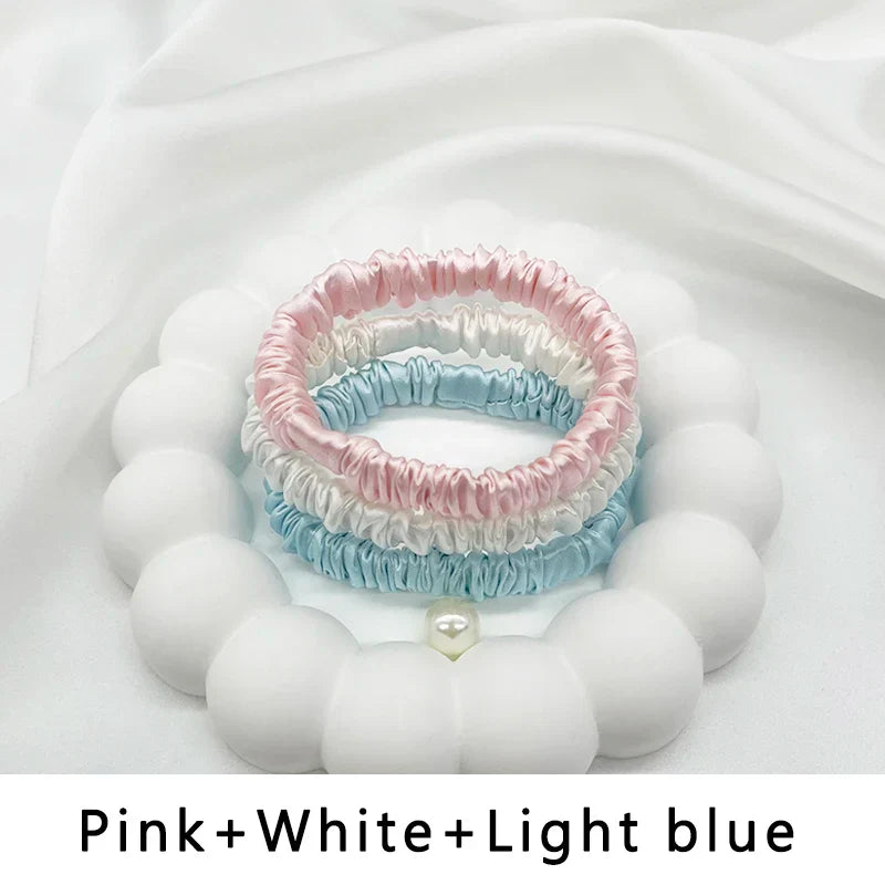 Three-piece silk hair band set in pink, white, and light blue. Gentle, frizz-free ponytail holders for natural hair and locs.
