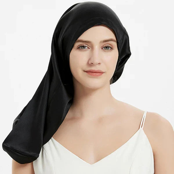 Black Mulberry Silk Sleep Bonnet for long hair, modeled by woman. Adjustable silk headwrap for frizz control and overnight protection.