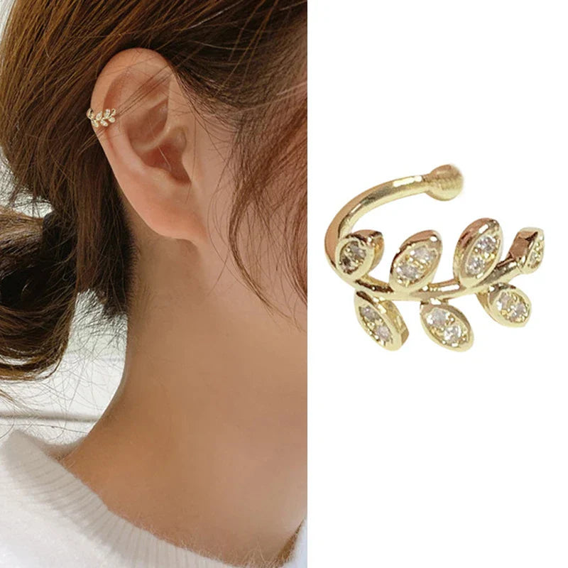 Gold-tone leaf-shaped ear cuff with rhinestone details worn by a model. Elegant and stylish modern vintage earrings for women.