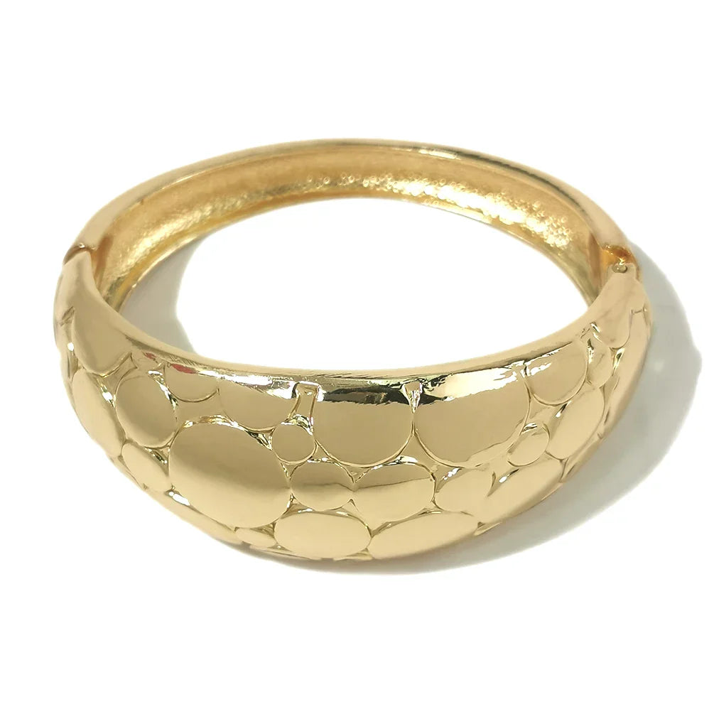 Gold-toned textured cuff bracelet with a unique bubble design. A stylish and elegant accessory for special occasions.