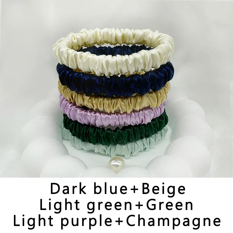 Six-pack of silk elastic hair bands in dark blue, beige, light green, green, light purple, and champagne. Gentle, frizz-free styling for all hair types.
