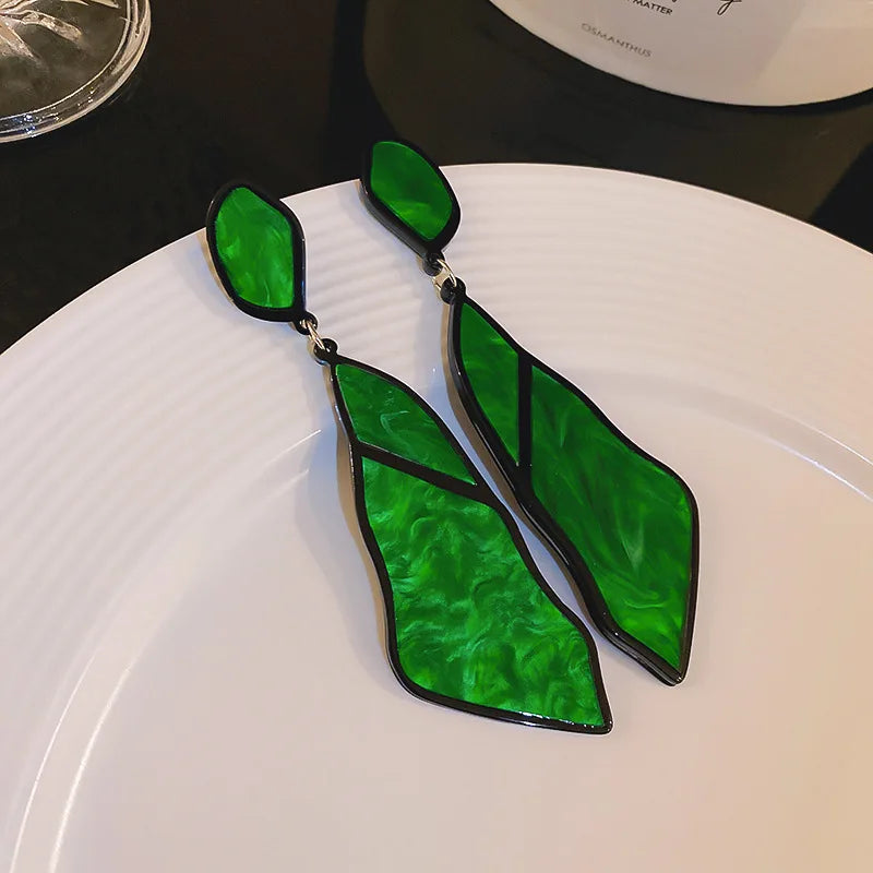 Blue Oceanic Shard Drop Earrings held in hand. Geometric statement earrings with a marbled texture, great for bold and trendy fashion.