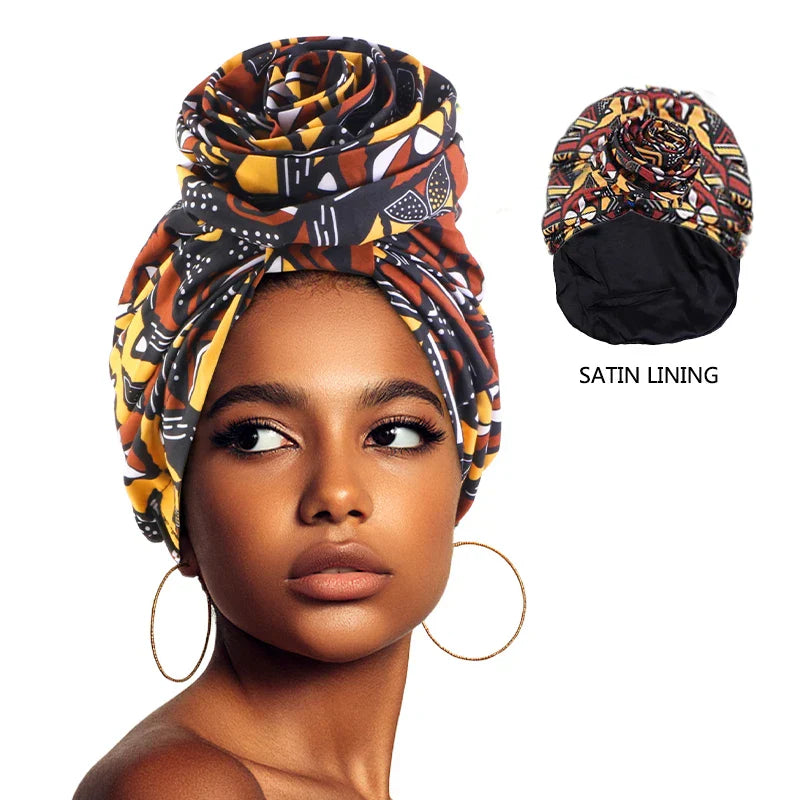 Afrocentric Melody Headwrap with satin lining, featuring a vibrant African print and pre-tied floral design. Stylish and protective hair accessory for women.