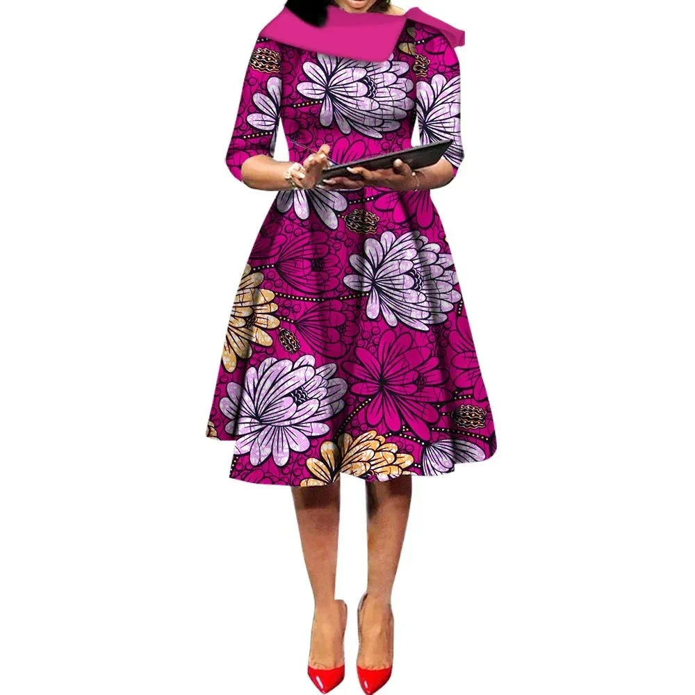 African Ankara Wax Print Midi Dress in vibrant pink with large floral patterns, three-quarter sleeves, and a flowing midi skirt.