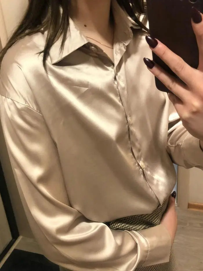 Soft champagne satin blouse with a relaxed fit, styled with a brown clutch. A perfect blend of elegance and comfort for any occasion.