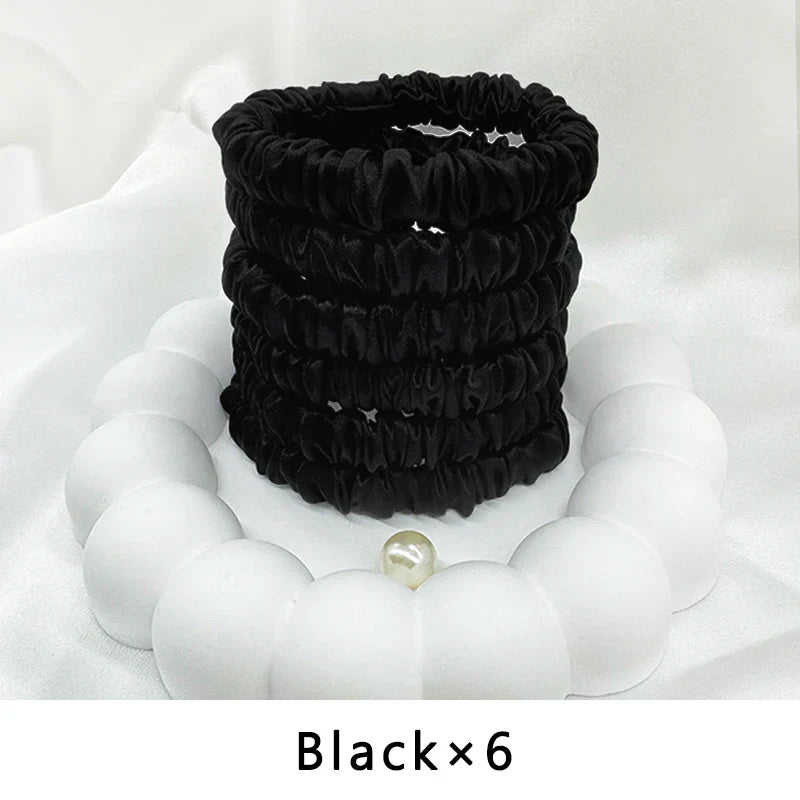 Six black mulberry silk elastic hair bands. Smooth, frizz-free ponytail holders for all-day comfort and hold.