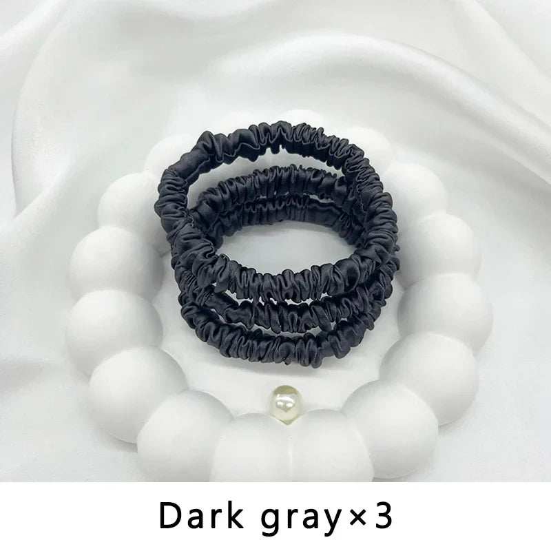 Three dark gray mulberry silk elastic hair bands. Ideal for frizz-free, gentle styling of textured and natural hair.