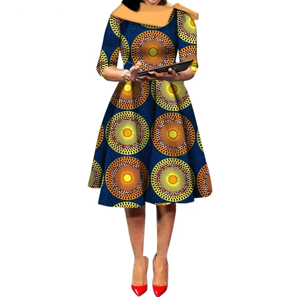 African Ankara Wax Print Midi Dress with a navy blue base and large circular sunburst patterns in yellow and orange.
