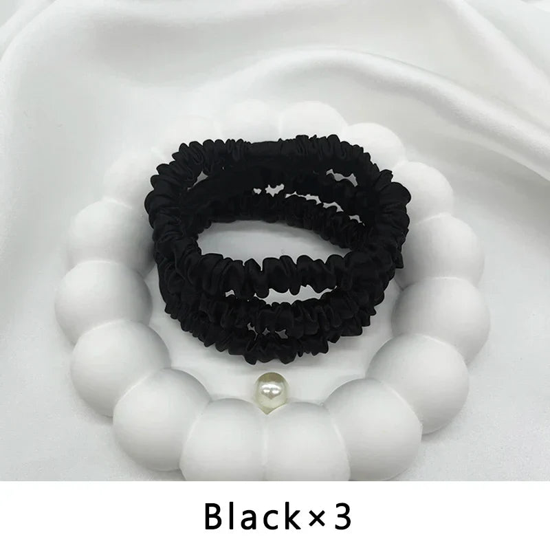 Set of three black mulberry silk elastic hair bands. Ideal for frizz-free, snag-free styling of all hair types.