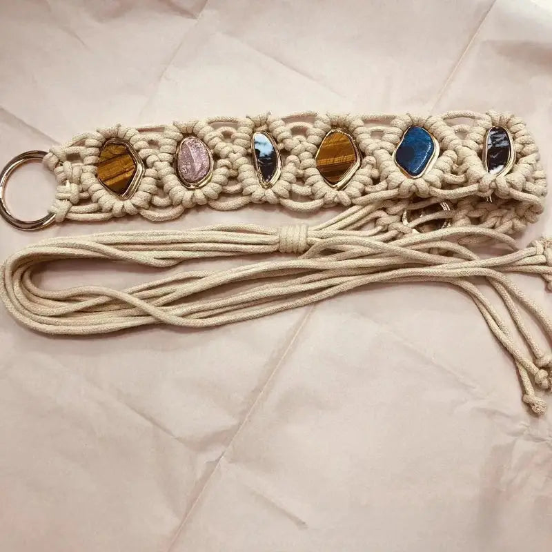 Artisan-crafted woven tassel belt featuring a braided macramé pattern and multicolored gemstones. Stylish and versatile for boho-inspired outfits.