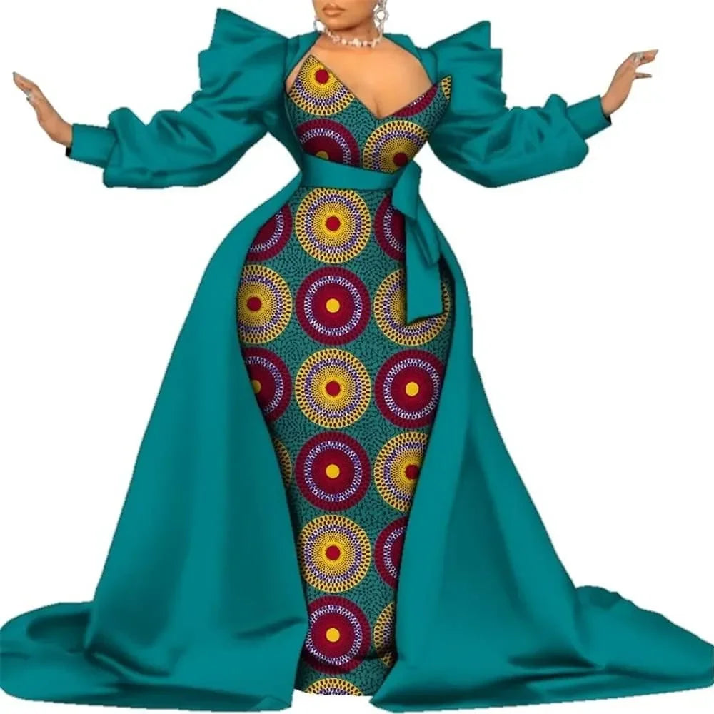 Teal satin overlay gown with a colorful circle-print panel, puff sleeves and a long train, on a white background.