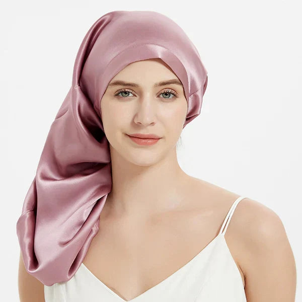 Rose pink Mulberry Silk Sleep Bonnet for long hair, modeled by woman. Smooth silk headwrap ideal for braids and frizz prevention.